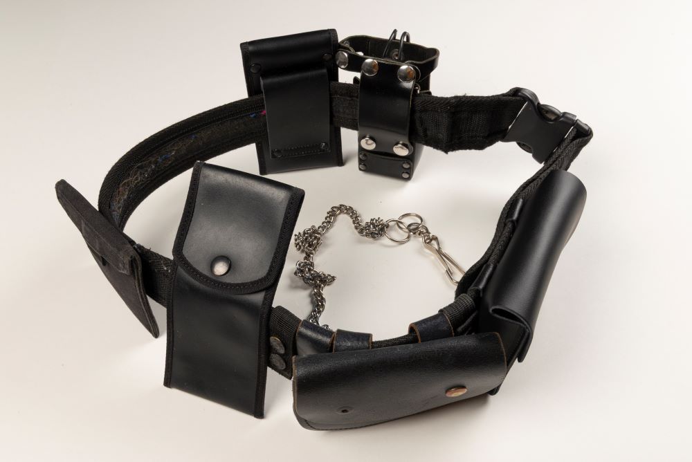 A prison nurse's belt. The belt is large and leather, with many pockets of different sizes attached.