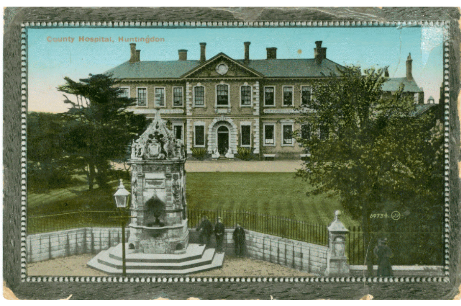 Postcard of view of The County Hospital, Huntingdon. A Coloured photograph of the grounds and main building, 1900. RCN Archive.