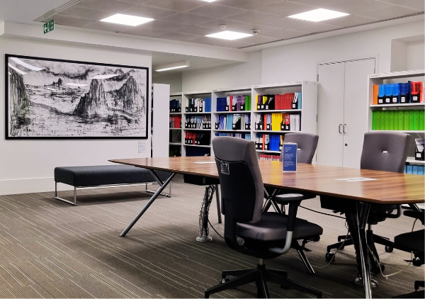 Desk infront of shelves and painting