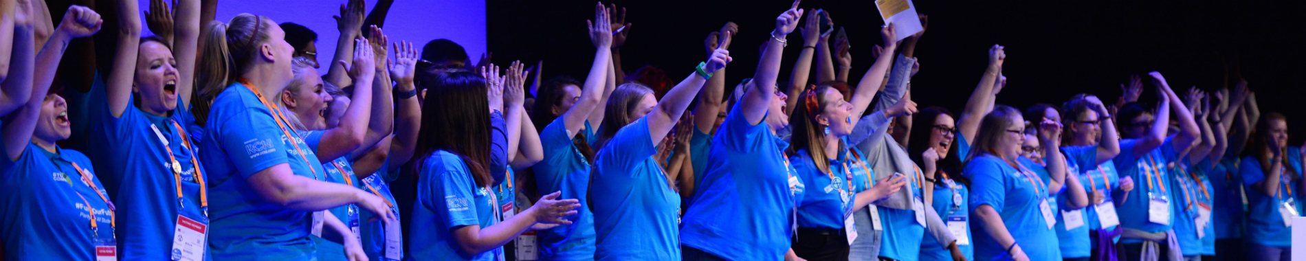 A group of RCN student ambassadors at RCN Congress. They're all wearing blur tshirts and are shouting in a celebratory way with their hands in the air