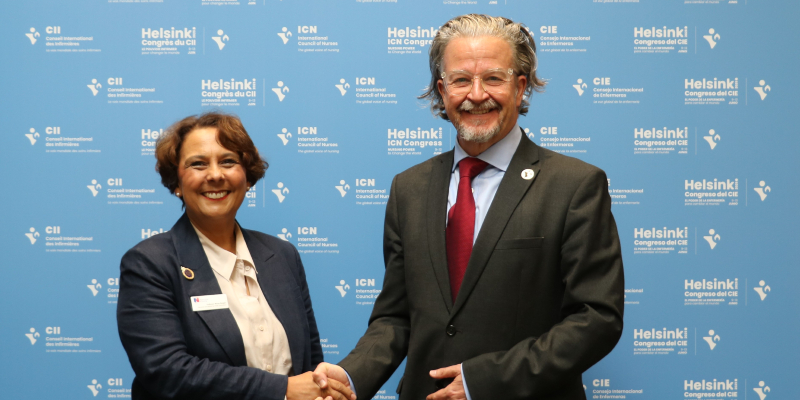 RCN General Secretary and Chief Executive Professor Nicola Ranger is pictured with Howard Catton, the CEO of the International Council or Nurses. They are smiling, shaking hands and looking at the camera