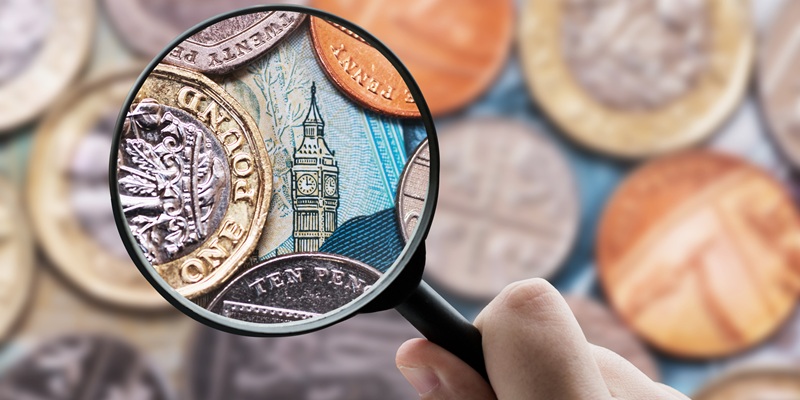 money with a magnifying glass showing westminster in glass