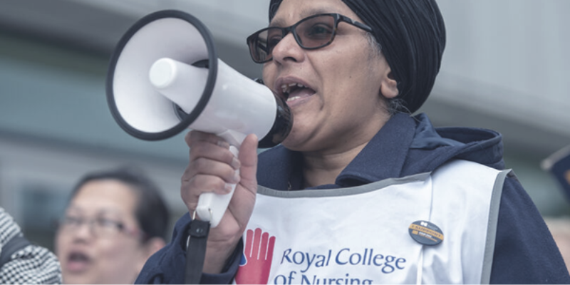 Person talking through megaphone wearing RCN tabard