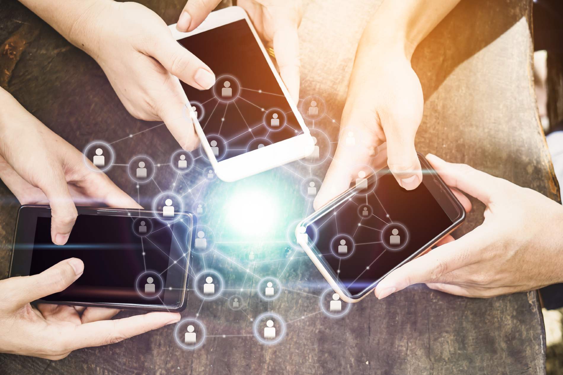 Group of hands holding mobile phones in a circle