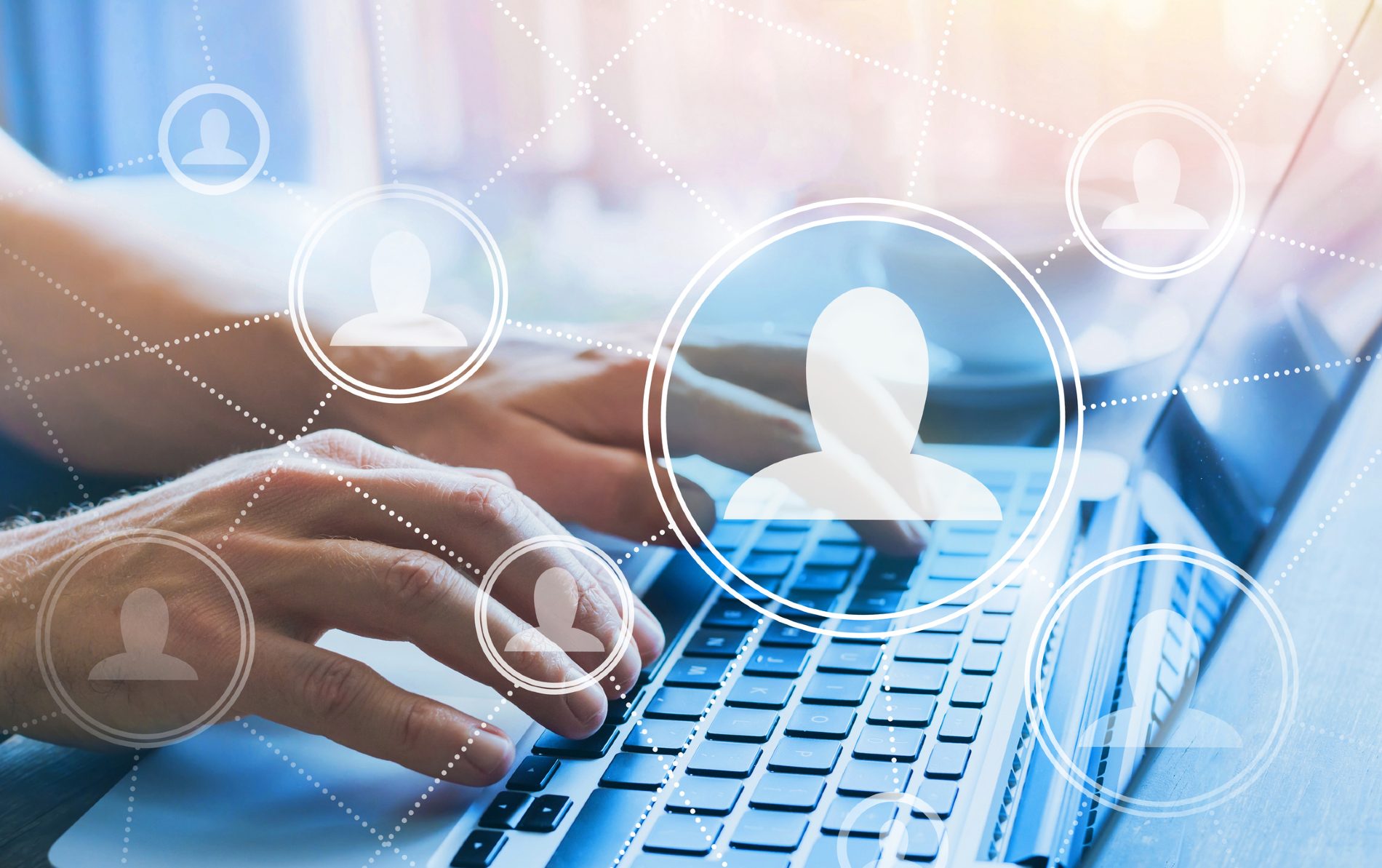 Someone using a laptop with an illustration of silhouettes connected by lines over the top to show a digital network