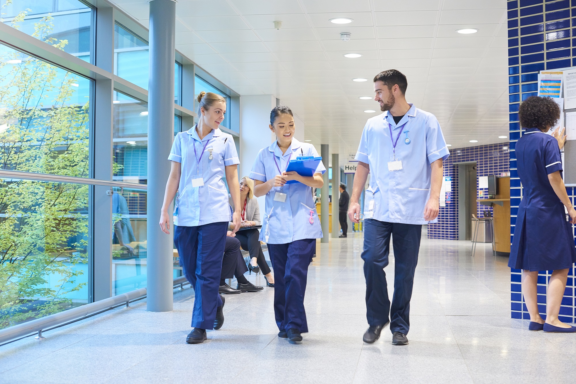 Three nurses walking down a hospital corridor