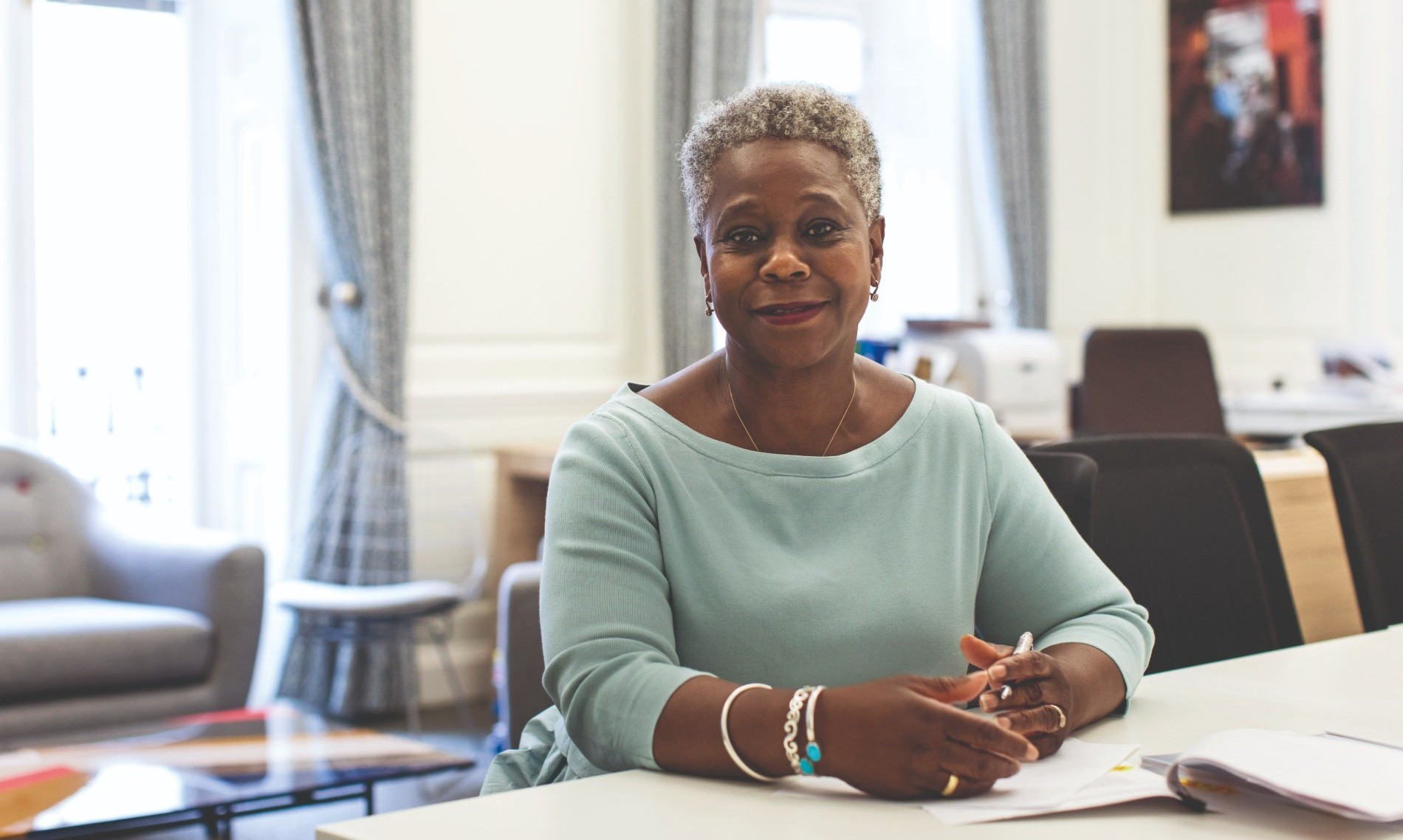 RCN Chief Executive & General Secretary Dame Donna Kinnair sat at a desk smiling