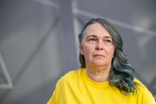 Nuring support worker Catalina wearing a yellow top and looking into the distance