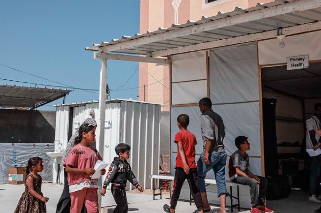 children walk past the field hospital in Gaza
