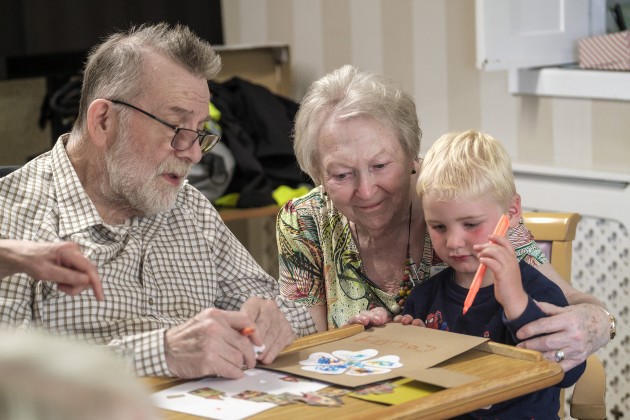Child drawing while being watched by adults at Bryn Marl Nursing Home