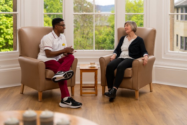 Nursing support worker Don sat alongside a woman, conversing.