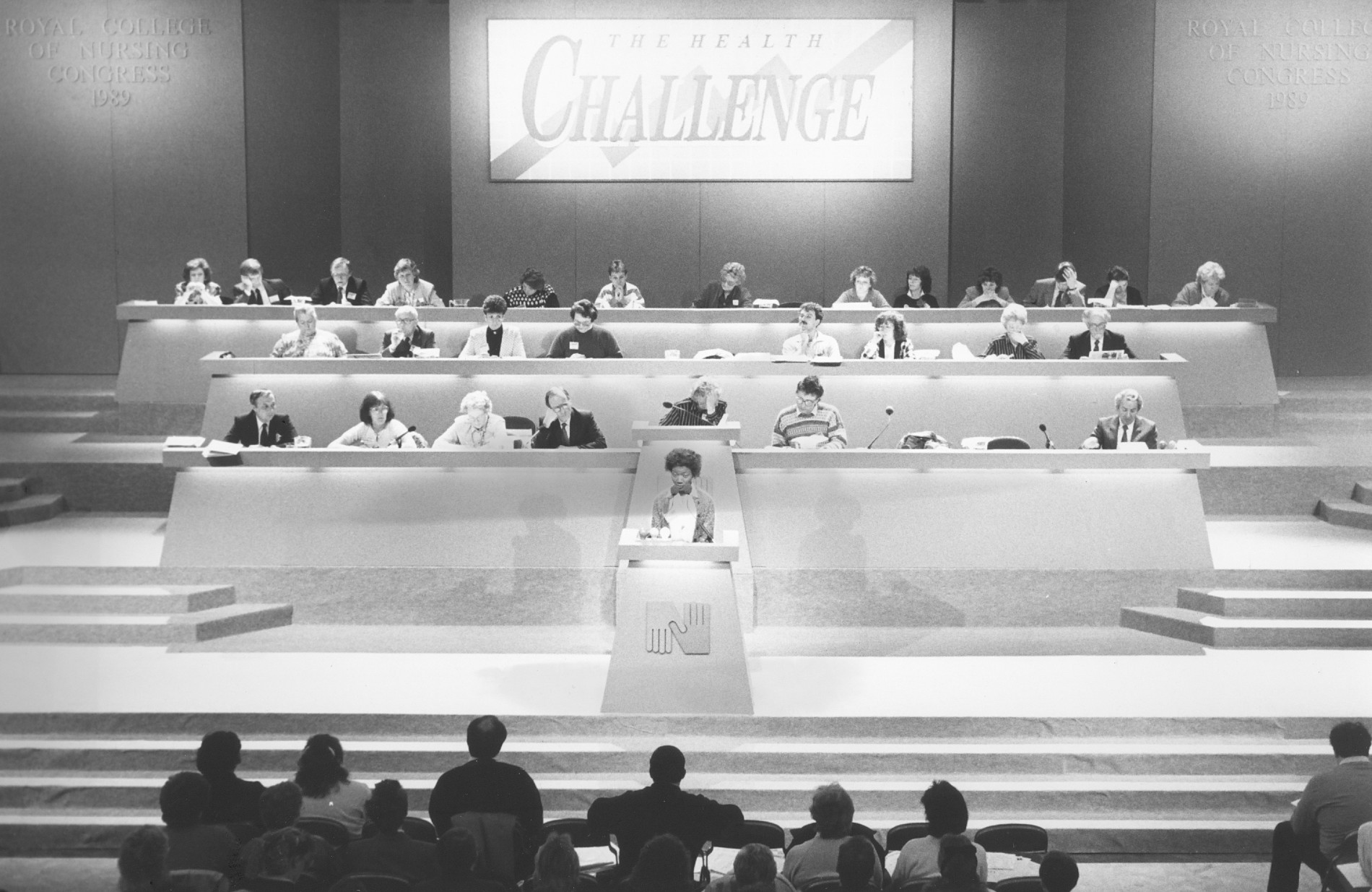 Black and white photo shows members seated on the stage at RCN Congress 1989