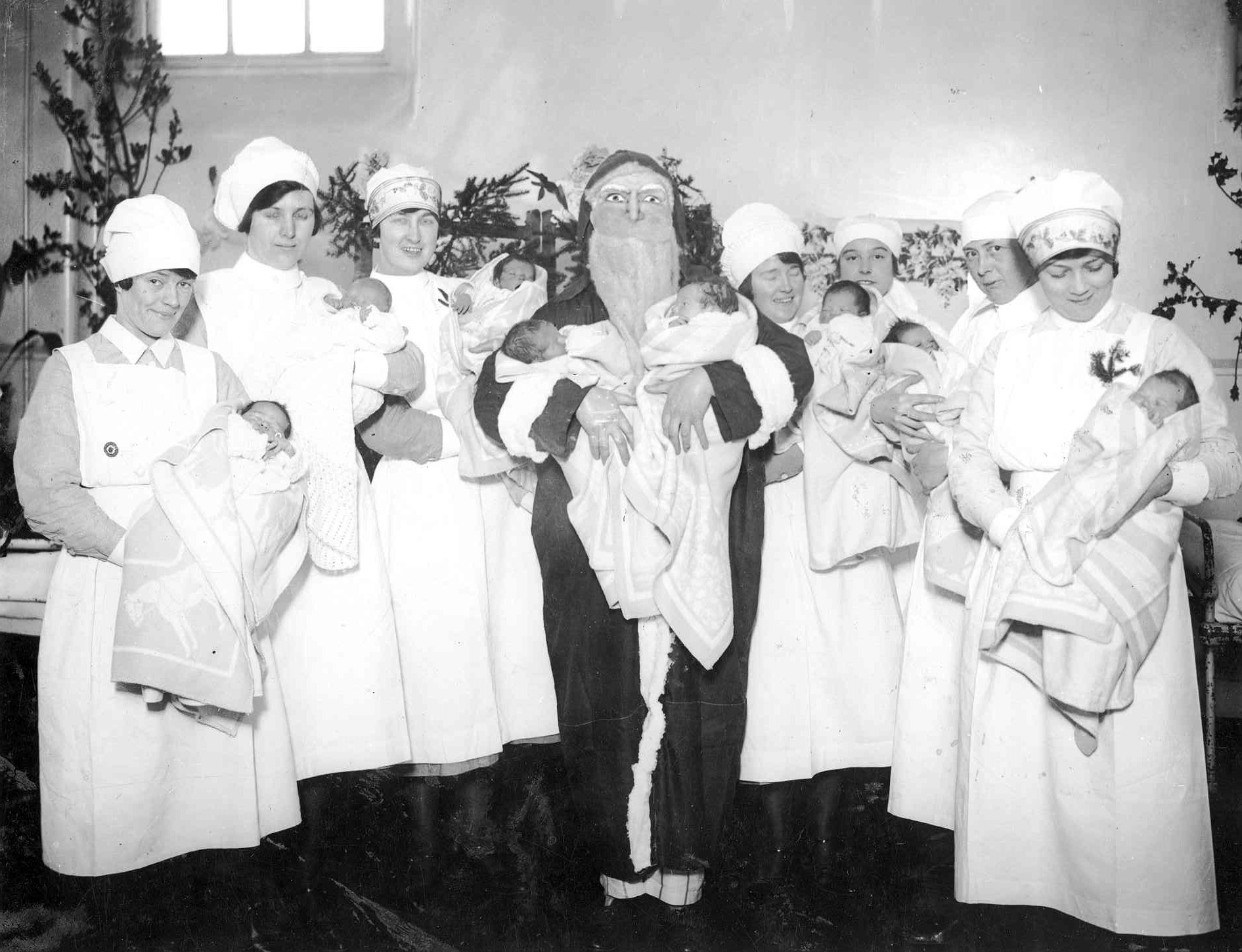 Santa and nurses hold babies on a maternity ward