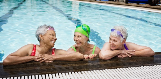 Three women look happy while relaxing in a swimming pool