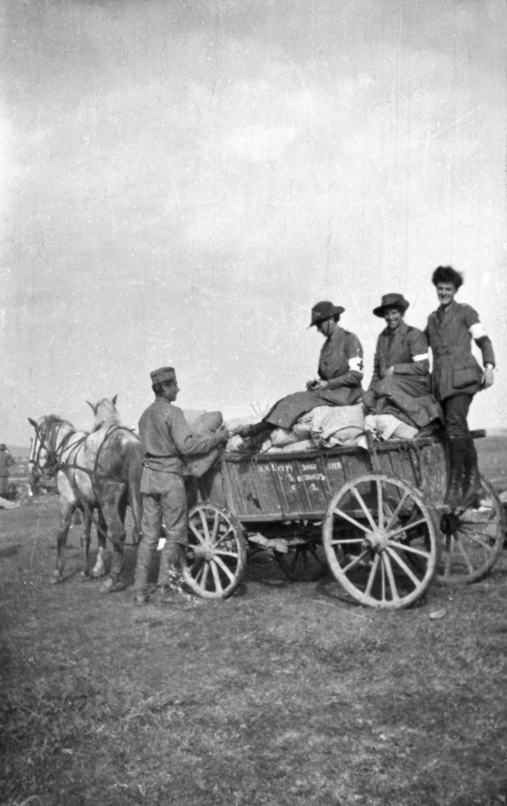 Three orderlies on cart in the uniform of the Scottish Women’s Hospitals group, Romania.